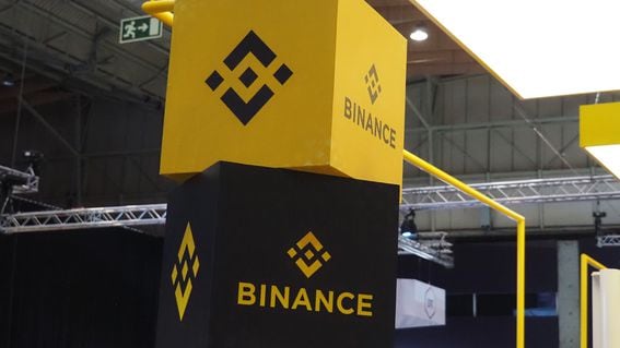 Two large stacked blocks displaying Binance's logo at a trade show.